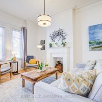 Living room with hardwood floors, original mouldings, and fireplace